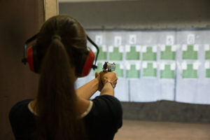 A woman shooting a pistol at targets on a shooting range