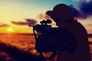 Male Hunter With Rifle On Natural Background
