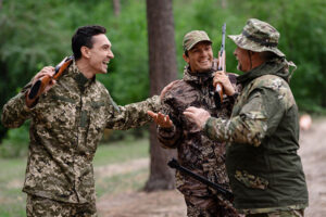 Three friends in hunting cammo gear are having a spirited conversation