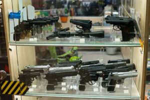 A variety of firearms in a gun display case at a gun store.