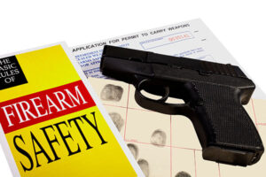 A firearm safety manual next to a pistol
