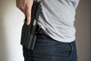 A man drawing his pistol from a holster on his hip