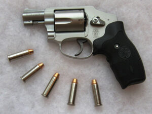 A Smith & Wesson 642 revolver with five rounds of ammo, and its characteristic double action only look without a hammer.
