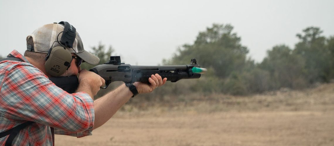 A man fires a shotgun on the range.